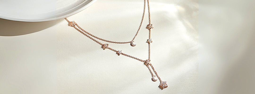 Rose gold necklace with small pendants on a light background