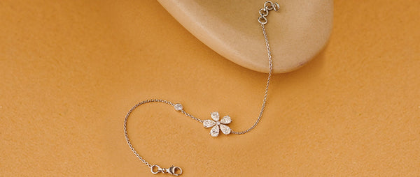 Delicate silver bracelet with a floral design on a beige background