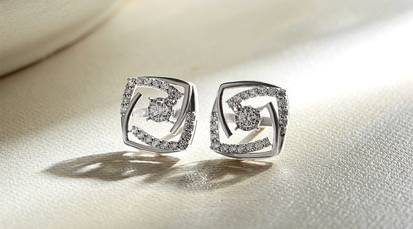 Pair of silver earrings with diamond accents on a light background Pair of silver earrings with diamond accents on a light background