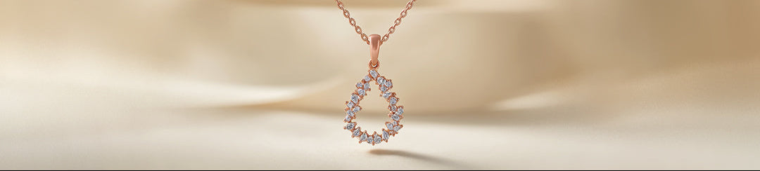 Rose gold necklace with a teardrop-shaped pendant on a beige background