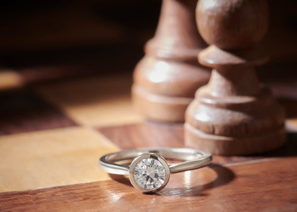 Diamond ring on a wooden surface with a blurred background
