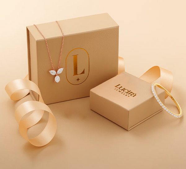 Jewelry set with necklace and bracelet on Lucira Jewelry branded boxes against a beige background