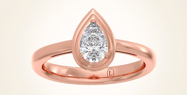 Rose gold ring with a pear-shaped diamond on a beige background