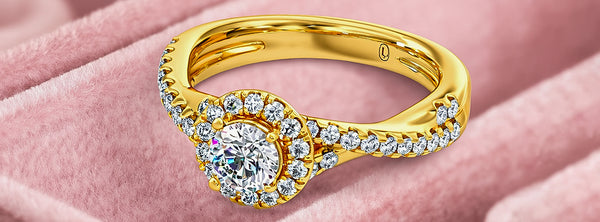 Gold ring with a diamond on a pink fabric background