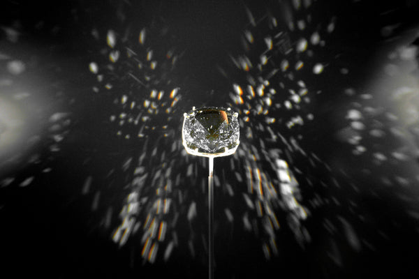 Diamond ring held above a spider web with sunlight filtering through
