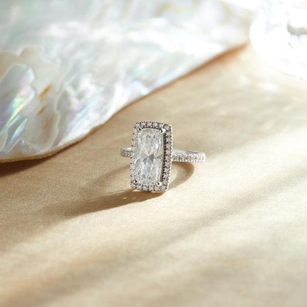 Silver ring with a diamond on a beige fabric background