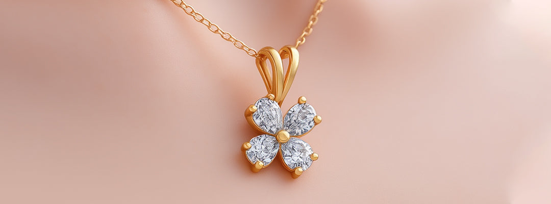 Gold necklace with a diamond flower pendant on a soft pink background
