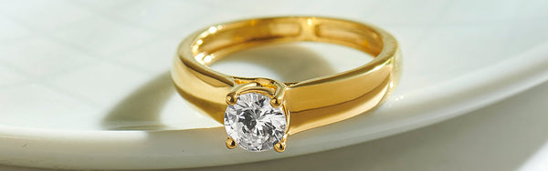 Gold ring with a diamond on a white background