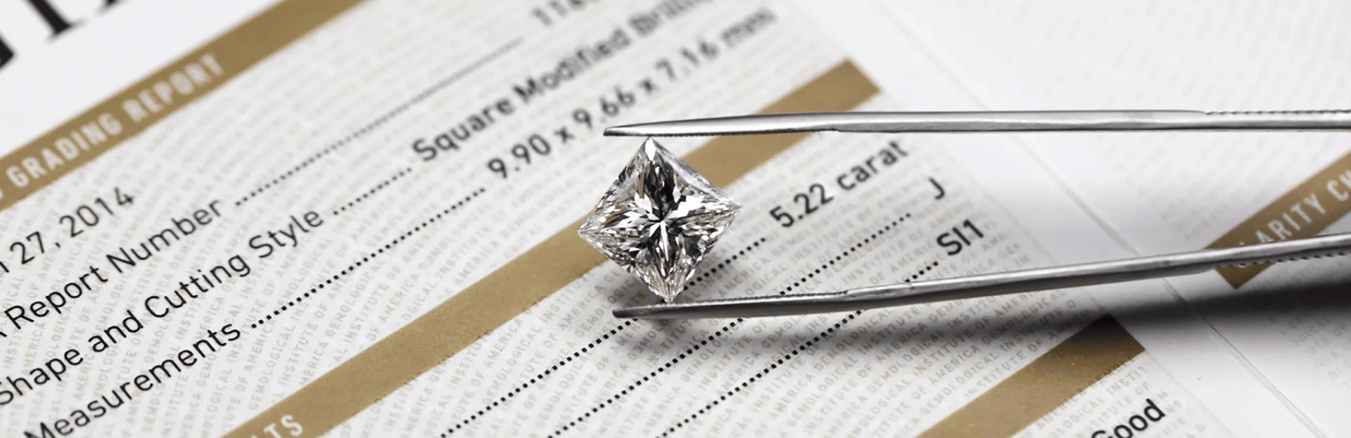 Diamond held by tweezers on a grading report