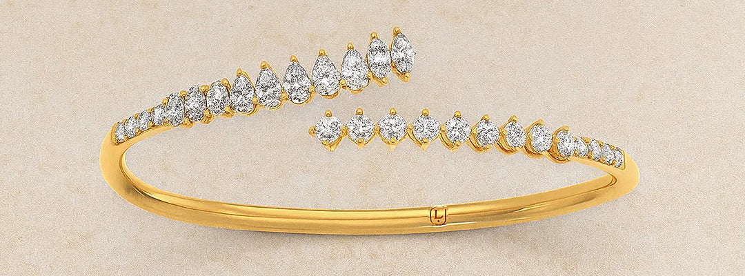Gold bracelet with diamond accents on a beige background