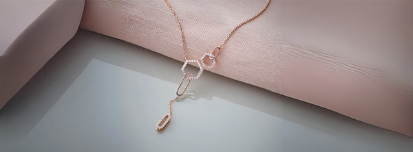Rose gold necklace on a soft pink fabric background