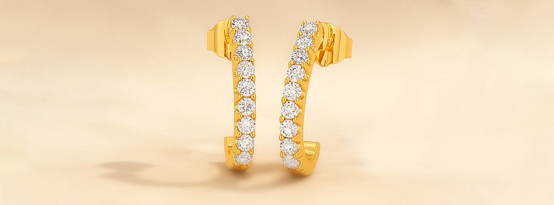 Gold hoop earrings with diamonds on a beige background