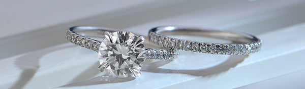Two diamond rings on a white surface